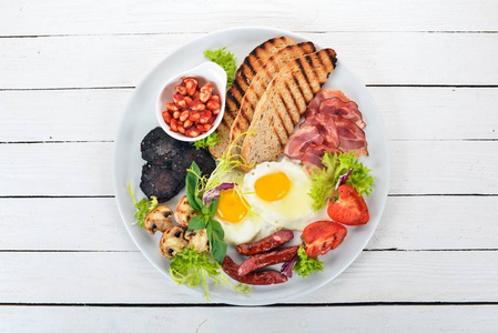 早餐。鸡蛋配培根和西红柿, 烤面包。顶部视图。在一个木质的背景。复制空间