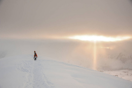 滑雪板在山顶上用太阳光线与天空一起行走