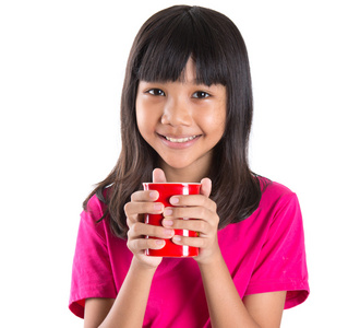 青春期前的亚洲年轻女孩与红色杯子