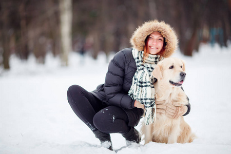 黑色夹克女孩的图片在冬天蹲在狗旁边