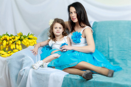 妈妈和女儿在沙发上用一束鲜花