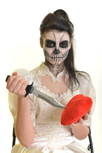 年轻女子在死面具骷髅脸艺术的一天照片