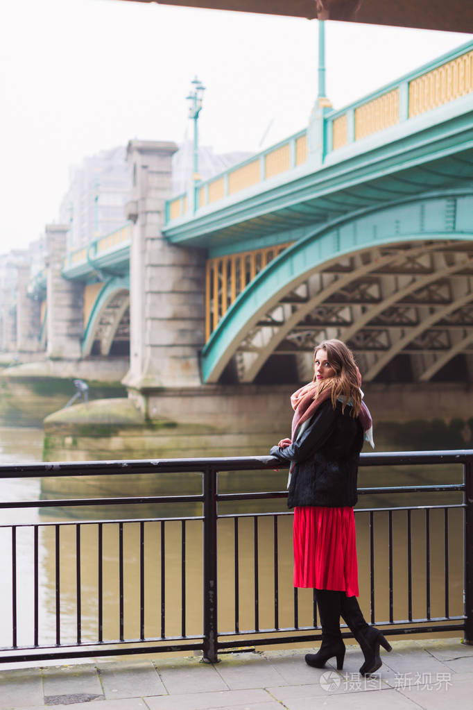站在河边的年轻优雅漂亮的女人, 依靠栏杆