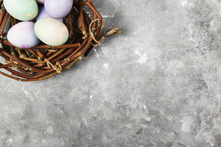 多彩多姿的蛋为复活节在巢在灰色背景。热门竞争