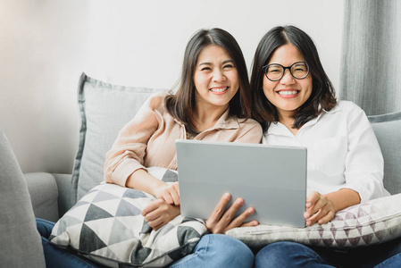 亚洲女性朋友用平板电脑微笑