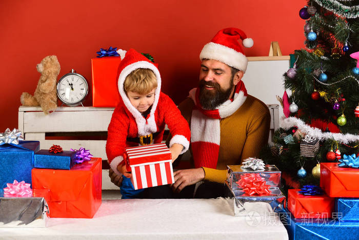 圣诞节家庭在红色背景上打开礼物