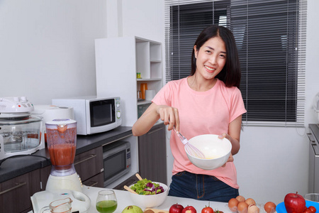 厨房里一个碗里煮鸡蛋的女人