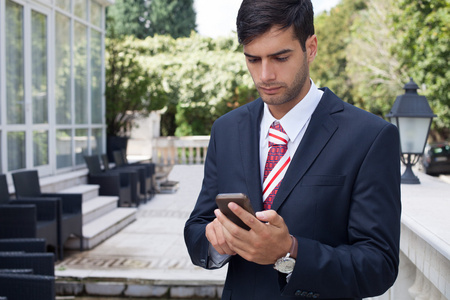 在大街上用智能手机的人照片