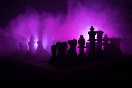 棋盘游戏概念的商业理念和竞争策略思想 concep。在黑暗背景下的象棋人物烟雾和雾。企业领导与信心理念