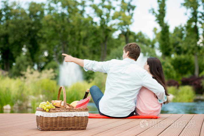 幸福浪漫的情侣享受湖附近的公园里野餐