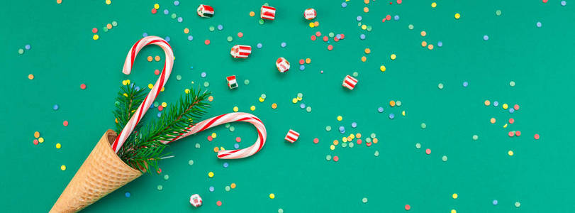 新年圣诞节圣诞佳节聚会庆祝华夫饼锥糖手杖冷杉树枝复制空间绿彩纸宽长横幅。模板贺卡2019
