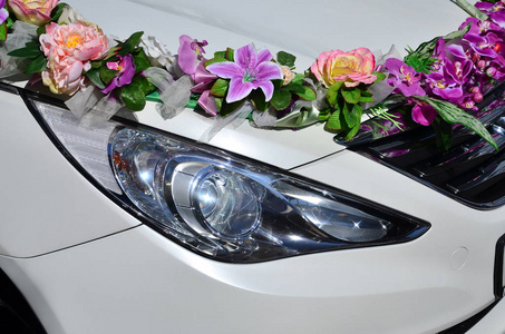 一张详细的汽车罩的照片, 装饰着许多不同的花。汽车准备举行婚礼。