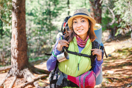 带着背包的年轻快乐的女人沿着小径小径独自漫步在山中, 户外活动的概念和大自然的冒险
