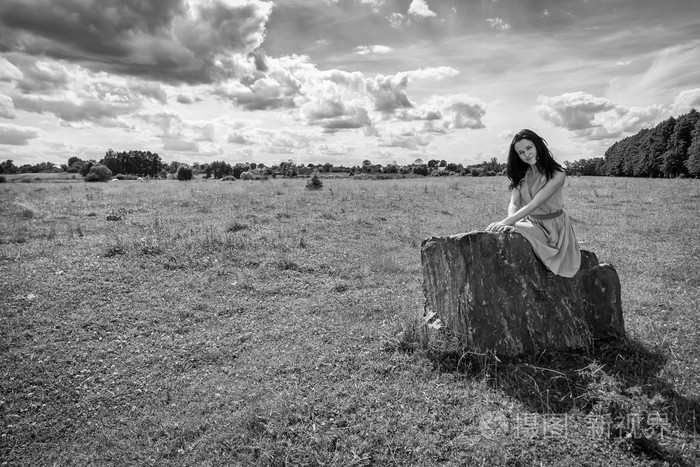 深色头发的女人坐在石头上