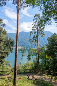 弯曲的道路与树木和椅子。科莫湖和山上的背景。意大利