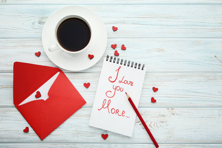 红心带信封和杯咖啡在木桌上
