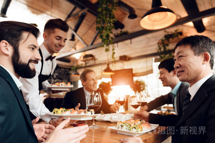 侍者在餐厅与中国商人会面时带寿司