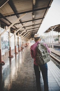 年轻的时髦男子步行通过火车站。在站台等候火车的人。旅游理念