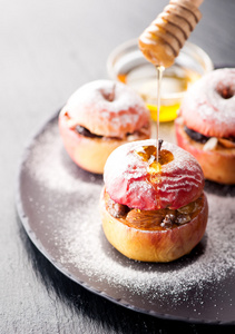 烤的苹果塞满了蜂蜜, 葡萄干和坚果照片