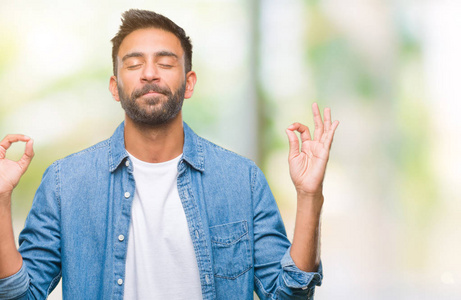 成年西班牙裔男子在孤立的背景下放松和微笑闭上眼睛做冥想手势用手指。瑜伽理念
