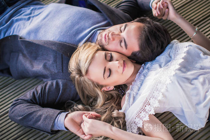 年轻可爱的情侣的肖像躺在户外头
