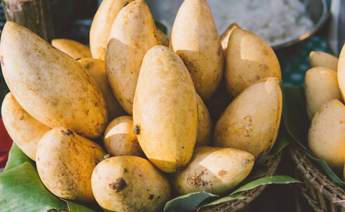 成熟的芒果在亚洲市场的货架上特写。热带水果和健康的生活方式。热带亚洲的芒果和其他水果