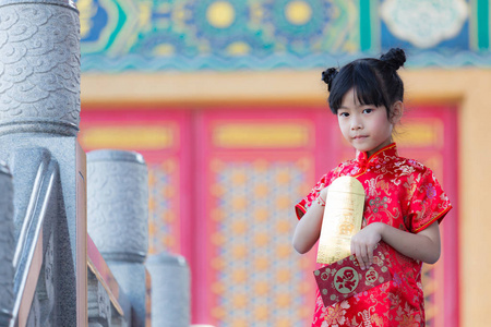 可爱的中国女孩打开金色和红色信封, 包含