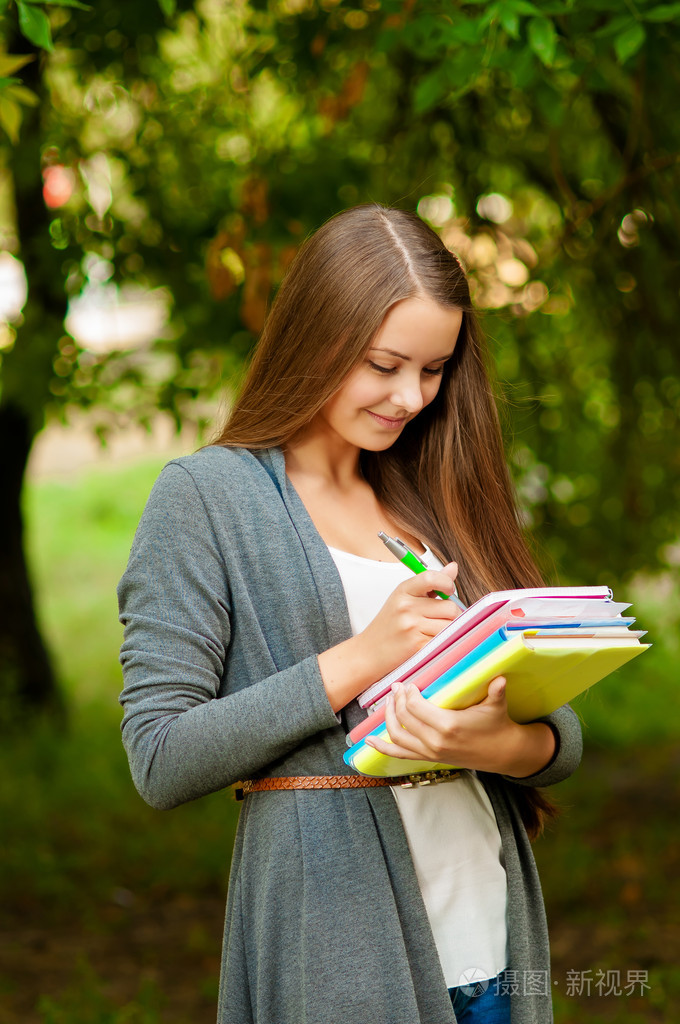 十几岁的女孩,手里拿着本书
