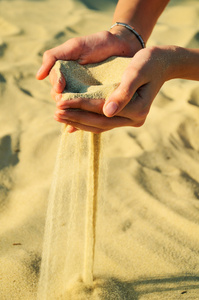 沙子倒出女性的手