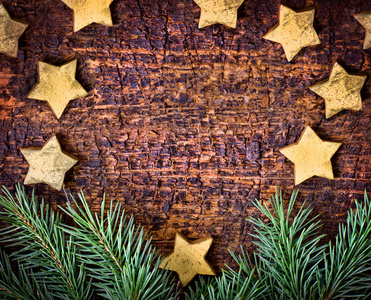 杉木分支和圣诞节装饰的星在褐色木质背景