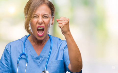 中年资深护士医生在与世隔绝的背景下生气和疯狂的举起拳头, 愤怒地大叫着。愤怒和侵略性概念