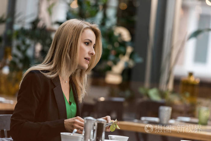 餐厅用餐的妇女侧面视图