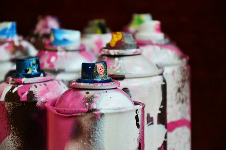 仍然生活与大量使用的彩色喷雾罐的气溶胶油漆躺在处理的木表面在艺术家的涂鸦车间。喷雾艺术用色罐