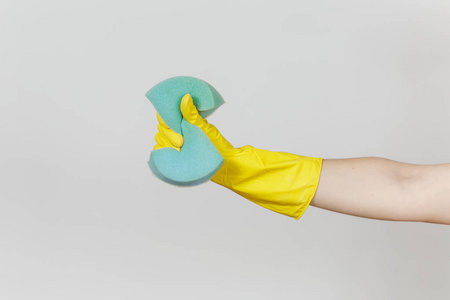 在黄色手套的女性手关闭, 并挤压蓝色大海绵清洗和洗碗在白色背景下隔离。清洁用品的概念。复制广告空间