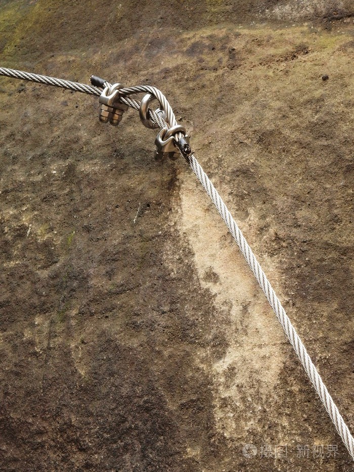 登山者的方式铁扭绳由螺丝钩固定在块中绳端锚定入砂岩岩石