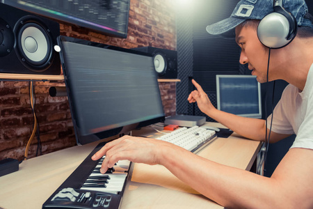 亚洲音乐制作人在家庭工作室安排一首关于数字录音设备的歌曲