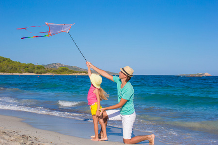 父亲和他的小女儿玩一起放风筝。