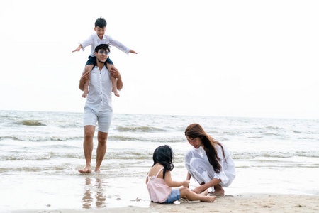 快乐家庭的父亲, 母亲和孩子去度假在热带沙滩在夏天