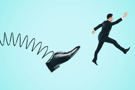 抽象的春天脚踢商人在蓝色背景.监督和解雇概念照片