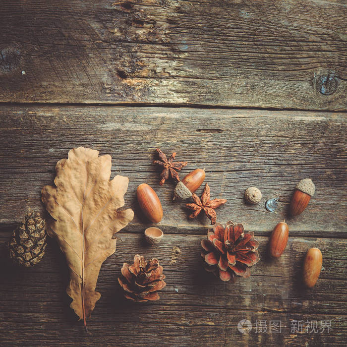 秋季作文。框架由秋天干燥叶子, 橡子, 松树锥体在黑暗的木制复古背景。秋天, 秋天, 背景。平躺, 顶部视图, 复制空间