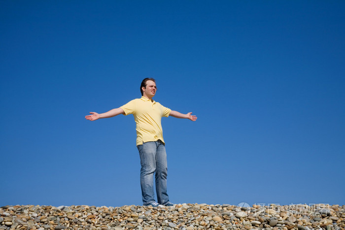 敞开双臂在海滩上的人