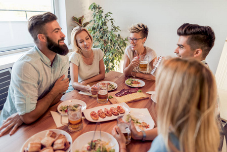 朋友会议。一群快乐的人带着眼镜, 聊天, 吃着健康的饭菜在宴会上在家里