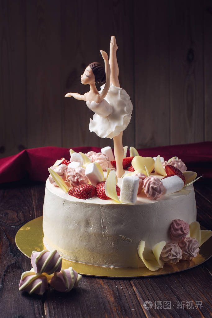 美丽的白色蛋糕装饰与一个舞蹈芭蕾舞演员, 草莓和棉花糖在顶部的雕像