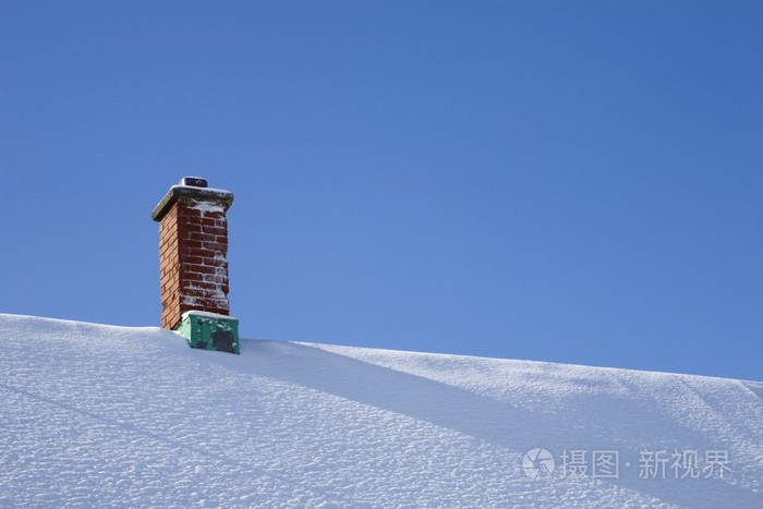 在白雪皑皑的屋顶上的烟囱