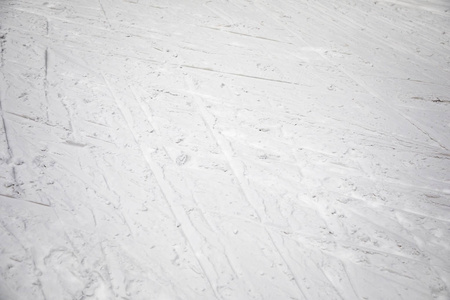 在阳光灿烂的日子在山中雪的滑雪痕迹