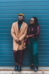 全长视图的时尚非洲裔美国人夫妇在夹克和大衣站在一起外面