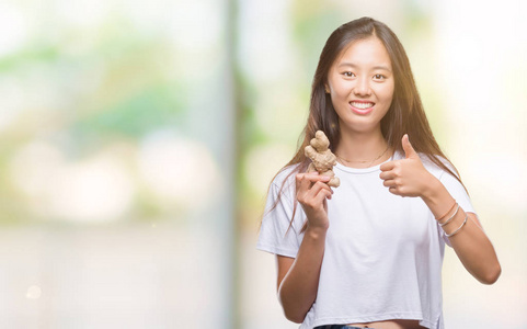 年轻的亚洲妇女持有新鲜的有机在孤立的背景下高兴的大笑做 ok 标志, 拇指与手指, 优秀的标志