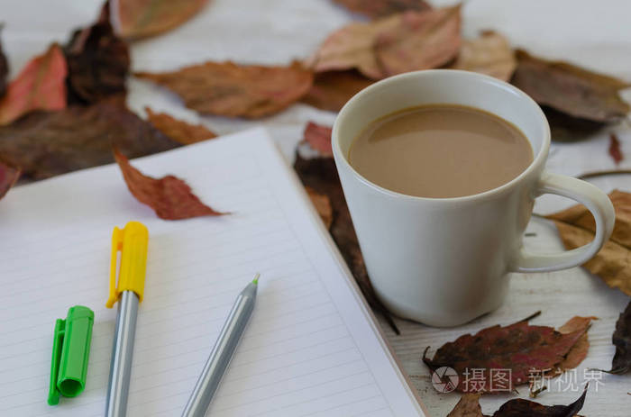 秋季概念。有秋叶, 咖啡杯, 笔记本和彩色铅笔在木桌上