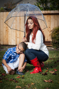 拉丁美洲母亲和儿子在雨中的与春季 mot 伞
