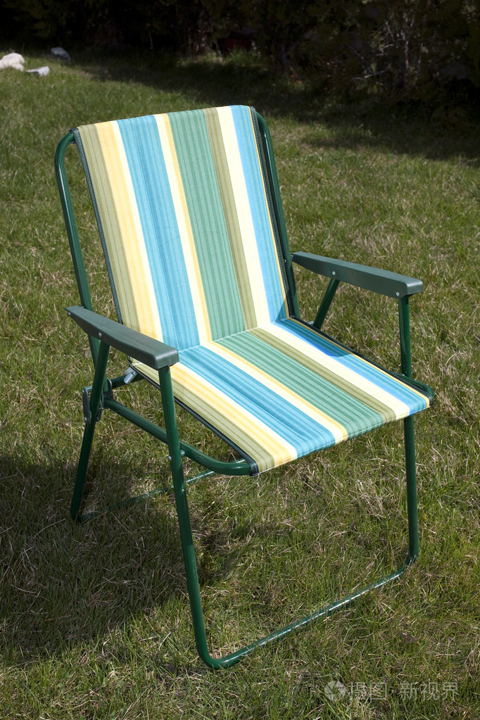 在花园里的绿色草地上帆布折叠椅